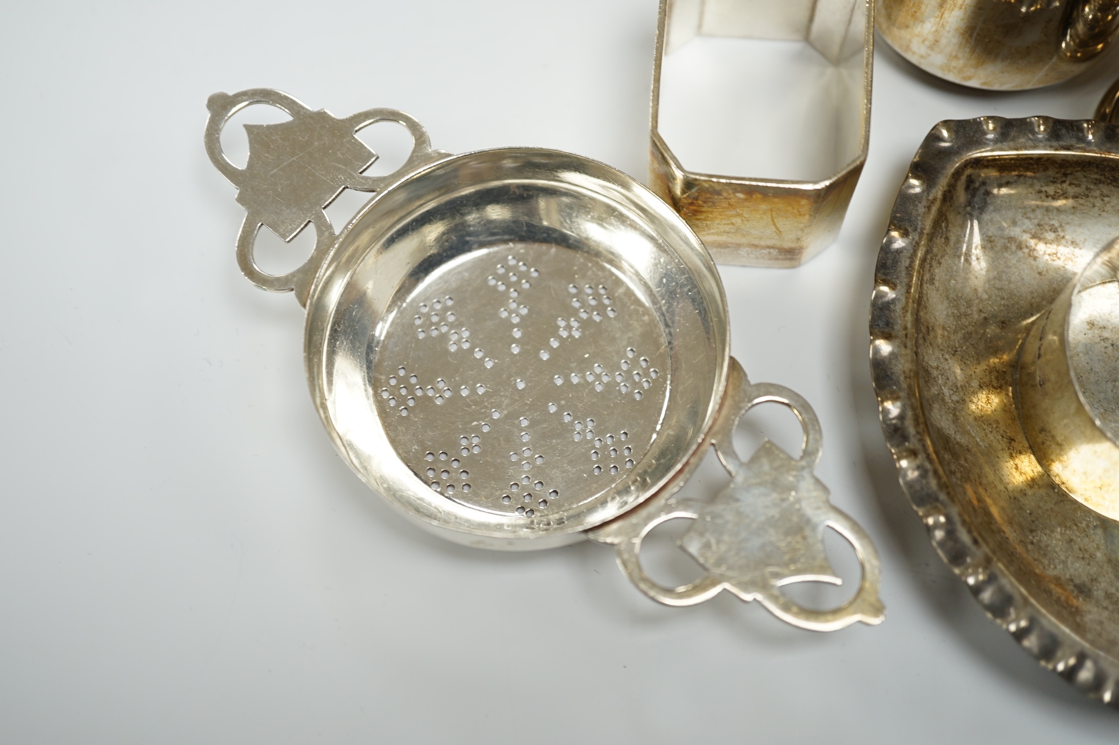 Assorted small silverwares including napkin rings, mugs, tea strainer and pair of Georgian sugar nips.